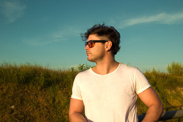 Portrait of a handsome man, under the sun in the field.