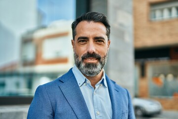 Middle age businessman smiling happy standing at the city.