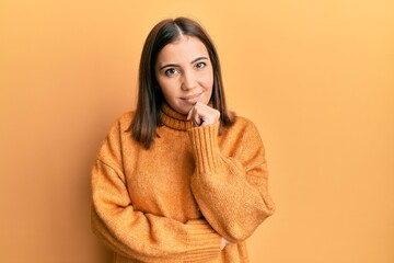 Sticker - Young beautiful woman wearing turtleneck sweater smiling looking confident at the camera with crossed arms and hand on chin. thinking positive.