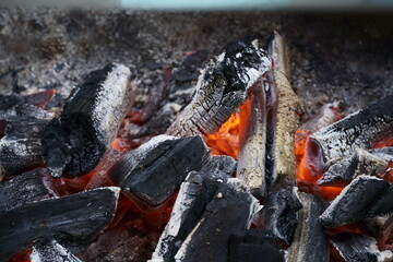 Macro closeup of red-hot coal on the barbecue. Flames of fire, coal, ember and smoke.