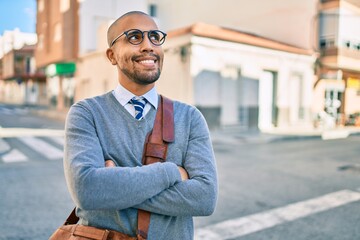 Sticker - Young african american businessman smiling happy walking at the city.