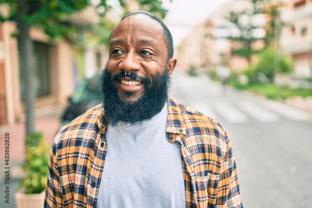 Handsome modern african american man with beard smiling positive standing at the street - obrazy, fototapety, plakaty 