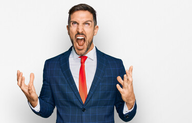 Sticker - Handsome man with beard wearing business suit and tie crazy and mad shouting and yelling with aggressive expression and arms raised. frustration concept.