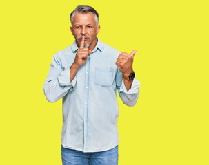 Sticker - Middle age grey-haired man wearing casual clothes asking to be quiet with finger on lips pointing with hand to the side. silence and secret concept.