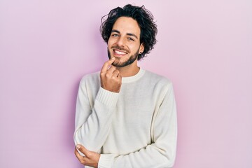 Canvas Print - Handsome hispanic man wearing casual white sweater looking confident at the camera smiling with crossed arms and hand raised on chin. thinking positive.