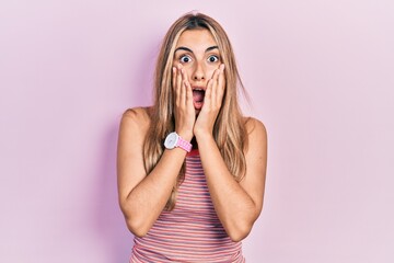 Sticker - Beautiful hispanic woman wearing casual summer t shirt afraid and shocked, surprise and amazed expression with hands on face