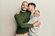 © Krakenimages.com - Homosexual gay couple standing together wearing casual clothes hugging oneself happy and positive, smiling confident. self love and self care
