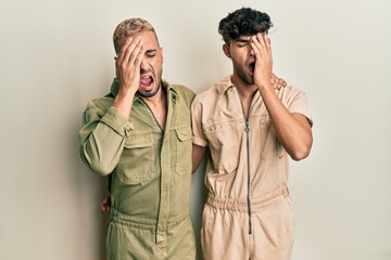 Sticker - Homosexual gay couple standing together wearing casual jumpsuit yawning tired covering half face, eye and mouth with hand. face hurts in pain.