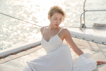 Sticker - Woman wearing white dress relax on sailing yacht, romantic sunset.