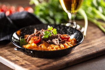 Wall Mural - Tomato sauce gnocchi with sous-vide beef and fresh tomatoes served in a dark plate