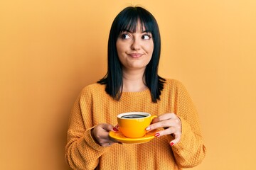 Sticker - Young hispanic woman holding coffee smiling looking to the side and staring away thinking.