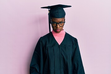 Poster - Young african american girl wearing graduation cap and ceremony robe skeptic and nervous, frowning upset because of problem. negative person.