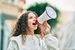 © Krakenimages.com - Hispanic child girl shouting angry using megaphone at the city.