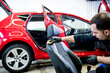 © romaset - Car service worker cleans a car seat with a special brush