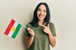 Young hispanic girl holding kurdistan flag smiling happy pointing with hand and finger