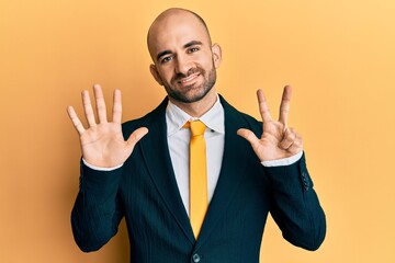 Sticker - Young hispanic man wearing business suit and tie showing and pointing up with fingers number eight while smiling confident and happy.