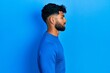 © Krakenimages.com - Arab man with beard wearing casual blue sweater looking to side, relax profile pose with natural face with confident smile.