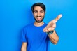 © Krakenimages.com - Young hispanic man wearing casual clothes smiling friendly offering handshake as greeting and welcoming. successful business.