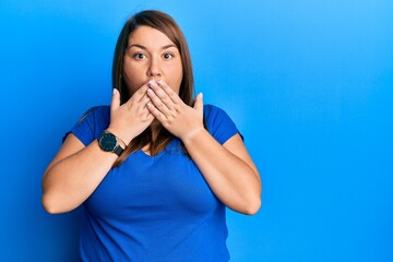 Beautiful brunette plus size woman wearing casual blue t shirt shocked covering mouth with hands for mistake. secret concept.