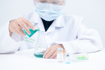 Wall Mural - a little scientist is pouring blue liquid chemical in erlenmeyer flask