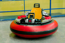 Rounded Red Car With Yellow Chair Stands At Indoor Amusement Park. Drive. Driver. Fun. Attraction. Happiness