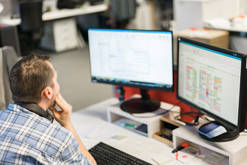 Unknown man sitting on chair and working on computer.