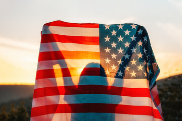 independence day. silhouette of woman holds an american flag in her hands, raised above her head. ba