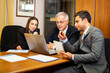© Minerva Studio - Group of businesspeople discussing while looking at a laptop screen