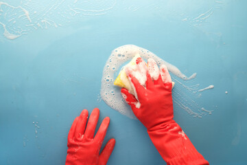 Sticker - man in protective rubber gloves holding a sponge and clean blue surface