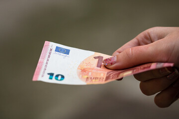 Sticker - Closeup shot of a female hand holding a euro banknote