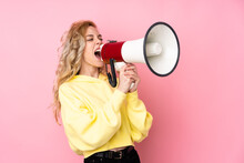 Young Blonde Woman Wearing A Sweatshirt Isolated On Pink Background Shouting Through A Megaphone