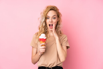 Canvas Print - Young blonde woman holding a cornet ice cream isolated on pink background shouting with mouth wide open