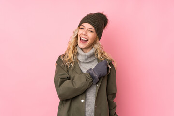 Canvas Print - Young girl with winter hat isolated on pink background celebrating a victory