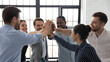 © fizkes - Business team of happy motivated staff employees giving joined hands high fives. Excited work group celebrating corporate financial success, good sales result, successful teamwork and achievement