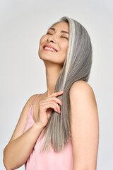 Vertical portrait of gorgeous happy joyful middle aged mature cheerful asian woman, senior older 50s gray haired lady eyes closed isolated on white. Ads of replenishing antiaging skin and hair care.