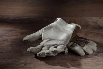 Work gloves on a wood surface with window light