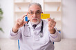 © Elnur - Old male doctor in credit card payment and vaccination concept
