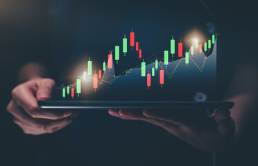 Stock exchange market concept, hand holding digital tablet with graphs analysis candle line on bokeh colors light.