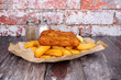 Battered cod fish and chips meal wrapped in brown paper