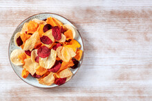 Colorful Vegetable Chips, Shot From The Top On A Plate With Copy Space On A Rustic Wooden Table