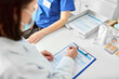 © Syda Productions - medicine, healthcare and pandemic concept - female doctor in medical protective mask with clipboard and nurse or medical worker at hospital