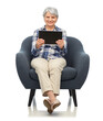 © Syda Productions - comfort, furniture and old people concept - smiling senior woman with tablet pc computer sitting in modern armchair over white background