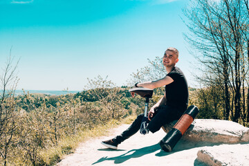 a man on a prosthetic leg travels the mountains. Dressed in black jeans and a T-shirt