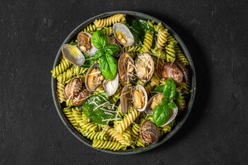 Wall Mural - Seafood pasta salad with vongole clams, fusilli, spinach, parmesan cheese, pine nuts and basil. Healthy food. top view