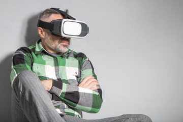 Man in virtual reality glasses over grey backgrou