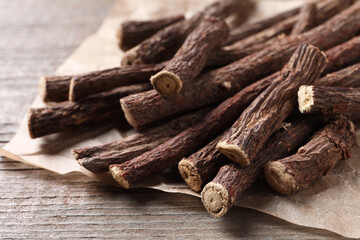 Dried sticks of liquorice root on wooden table, closeup