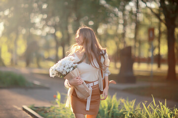 Wall Mural - girl holding a bouquet of flowers a walk in the park / romantic young beautiful cute model, love fee