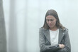 © PheelingsMedia - Sad woman walking a foggy day in a park