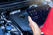 car service mechanic using digital tablet with diagnostics software to check engine condition. vehicle inspection