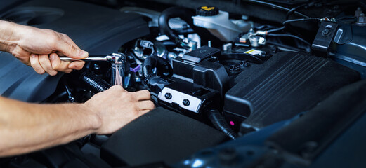 Wall Mural - mechanic working with wrench on vehicle engine in car service. maintenance and repair. banner copy s